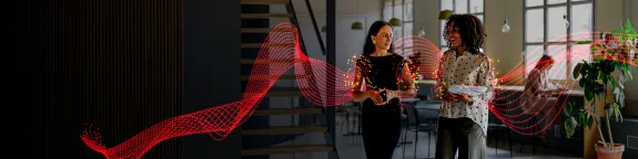 Two women walking through an office environment
